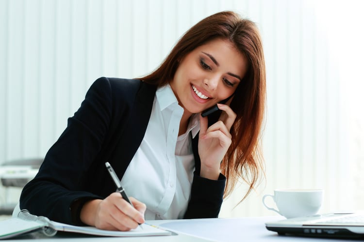 Buyer Persona Interviews | Businesswoman talking on the phone and writing notes